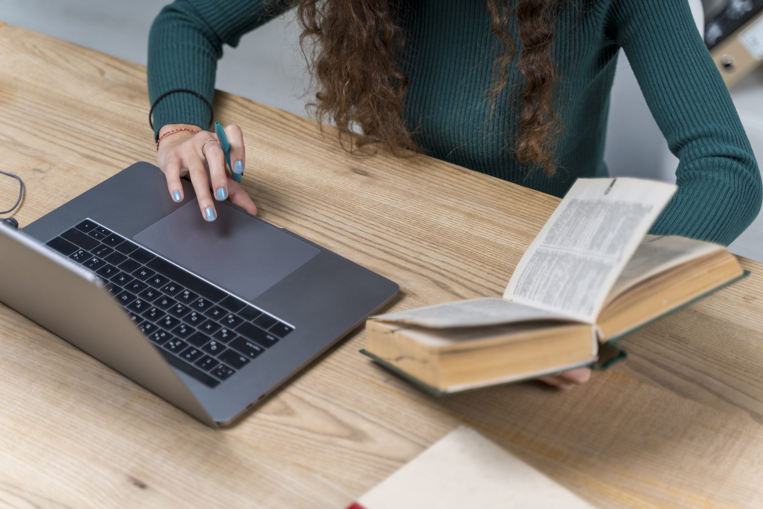 close-up-student-working-with-laptop-dictionary